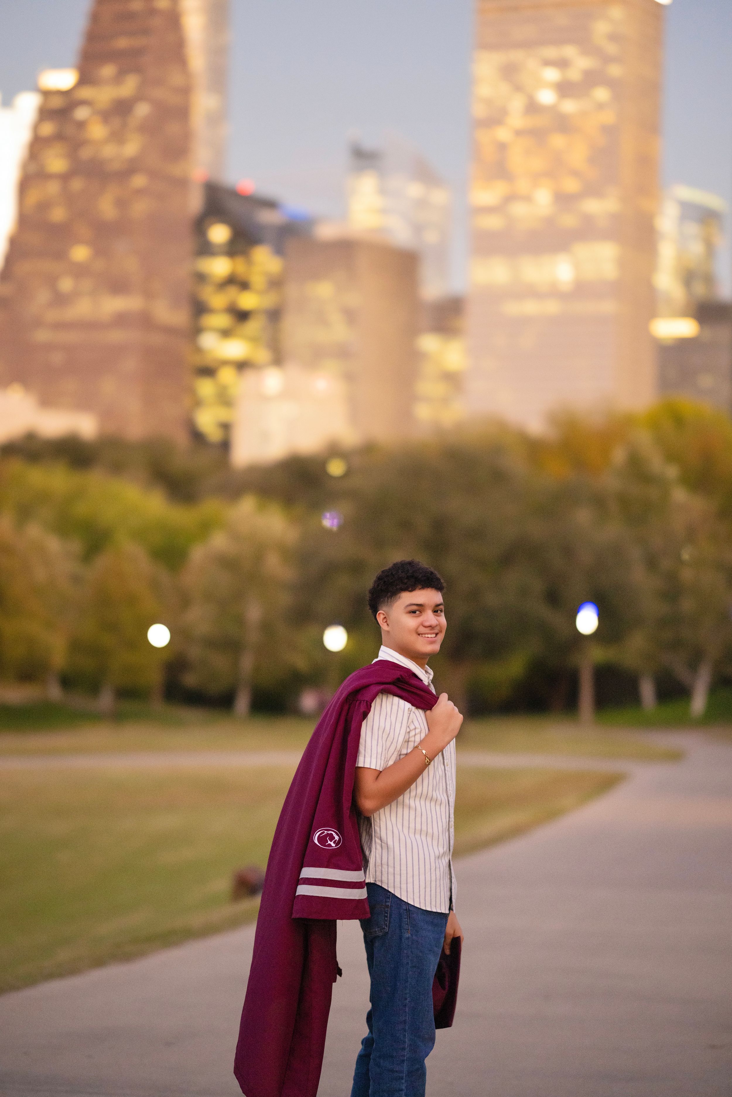 Urban portrait session with city skyline backdrop at sunset.