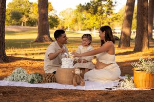 Family picnic gathering under trees during golden hour.