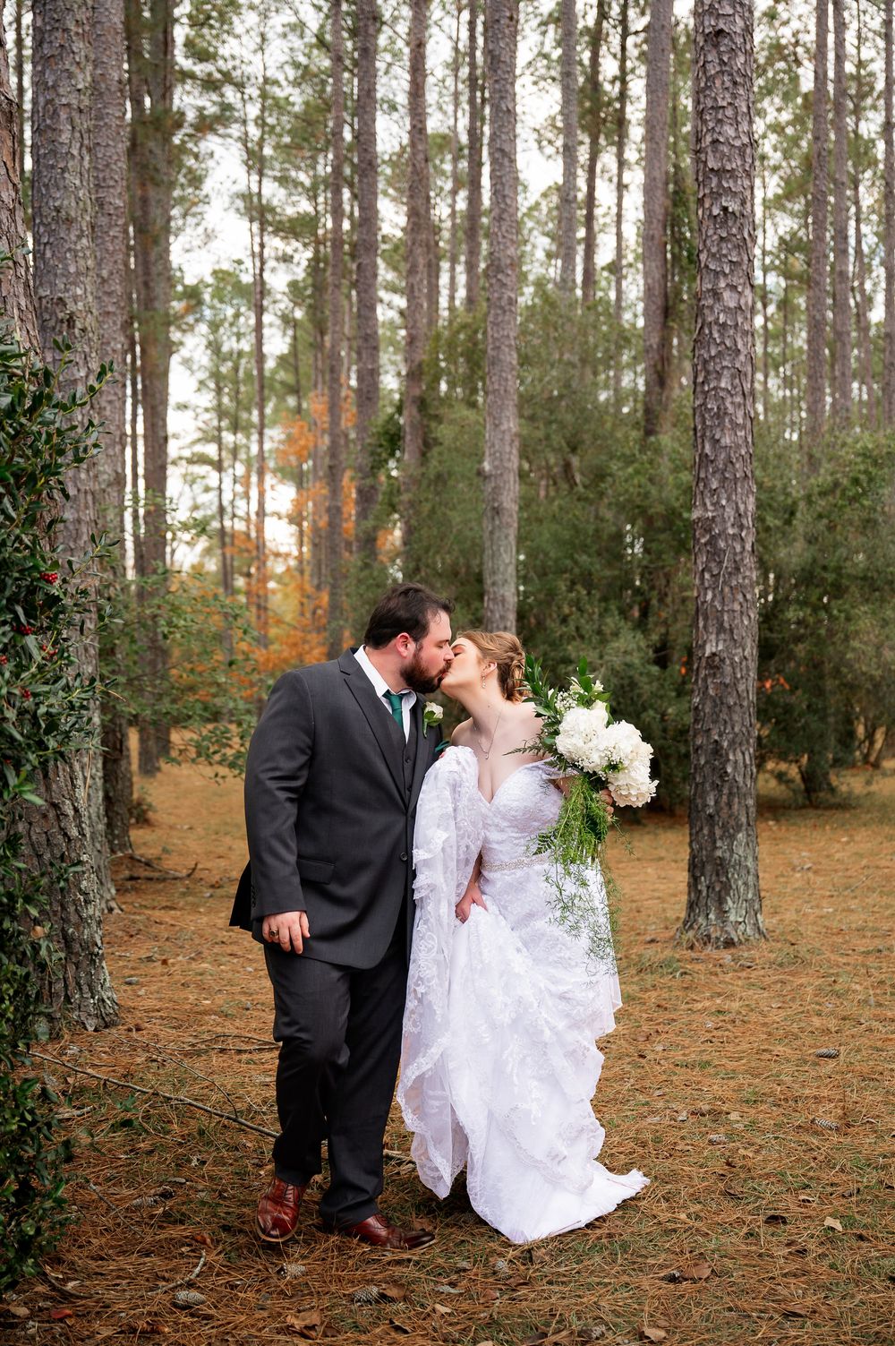 Intimate wedding portraits captured among tall pine trees in autumn.