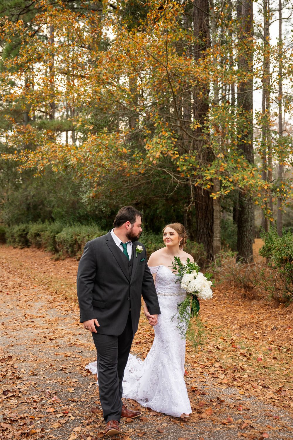 Romantic wedding photos taken in a forest with golden fall foliage.
