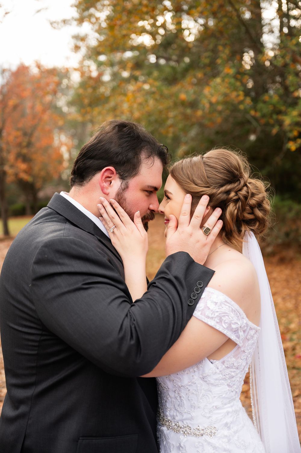 Tender moment between newlyweds during their autumn forest wedding photoshoot.