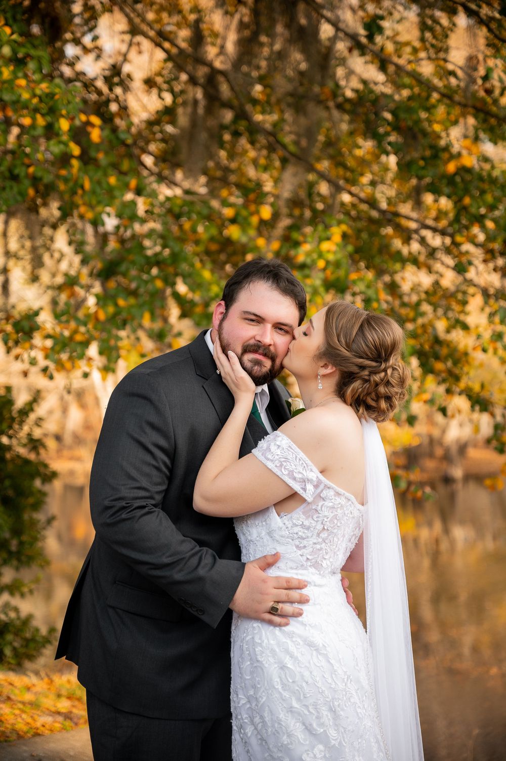Newlyweds share intimate moments against a backdrop of golden fall foliage.