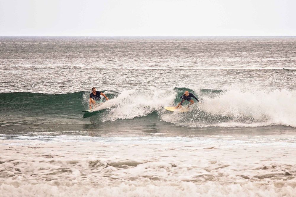 A series of surfing action shots showing waves breaking and surfers riding along the ocean waves.