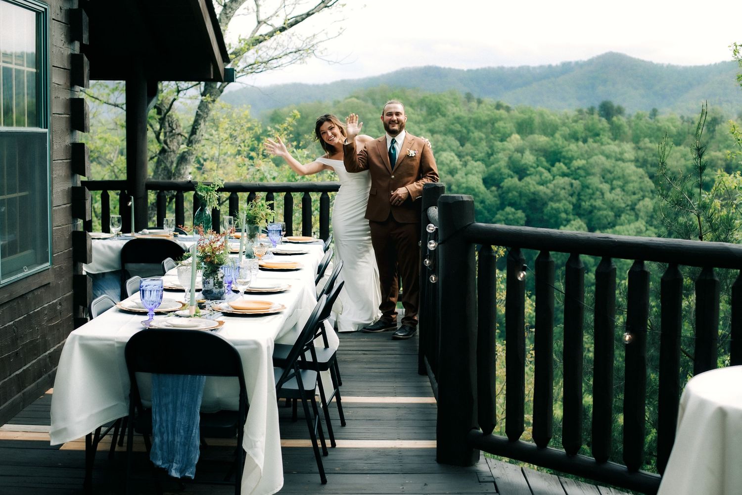 A rustic mountain lodge restaurant deck with panoramic forest views and elegant table settings for outdoor dining.
