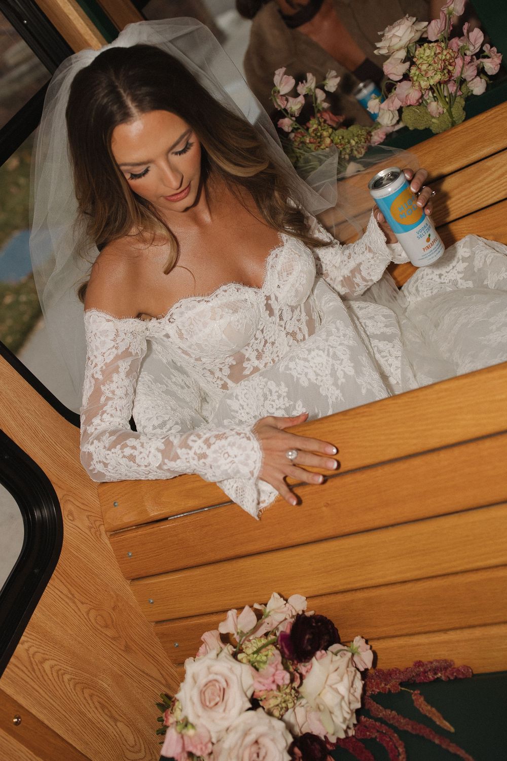 Close-up view of a delicate white lace wedding dress sleeve with floral details.