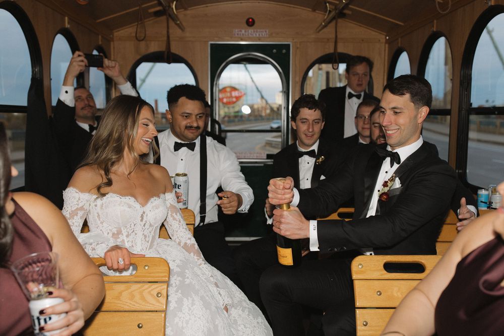 Wedding party celebrates inside a vintage train car during a reception.