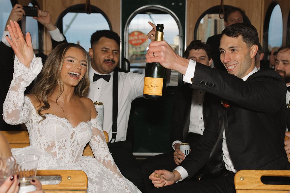 Wedding guests enjoying festivities and drinks inside a vintage train car.