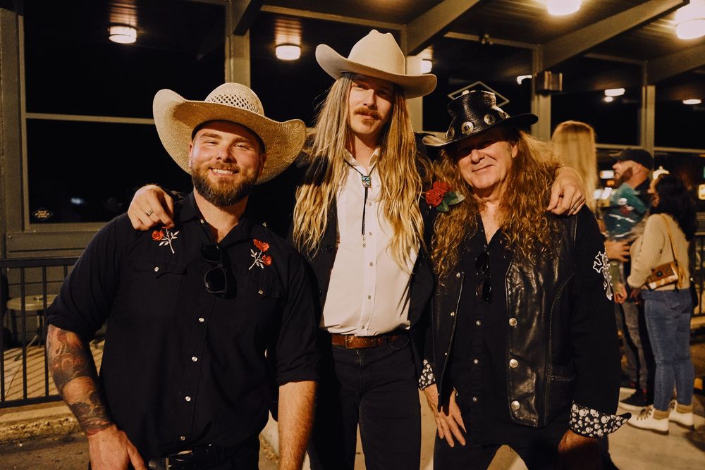 Casual western-themed party with guests in black attire and cowboy hats.