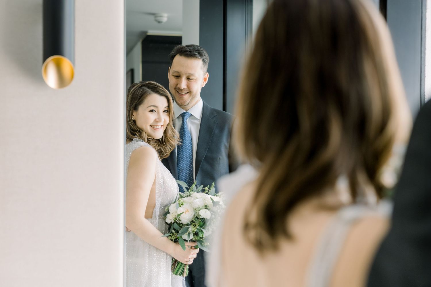 Elegant wedding couple shares intimate moments in a series of black and white photos in a bright modern venue.