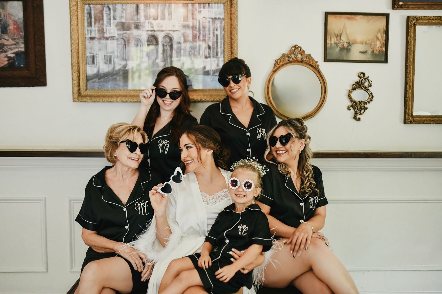 Bridal party wearing black pajamas and sunglasses while getting ready together before the wedding