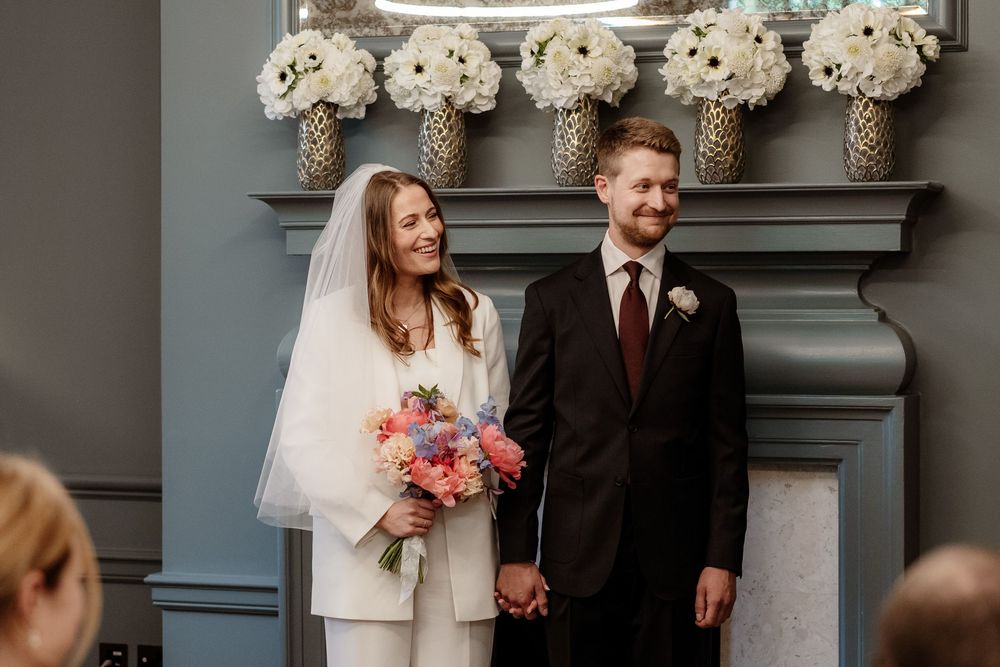 A wedding couple shares candid moments in a series of black and white photos against an elegant architectural backdrop.
