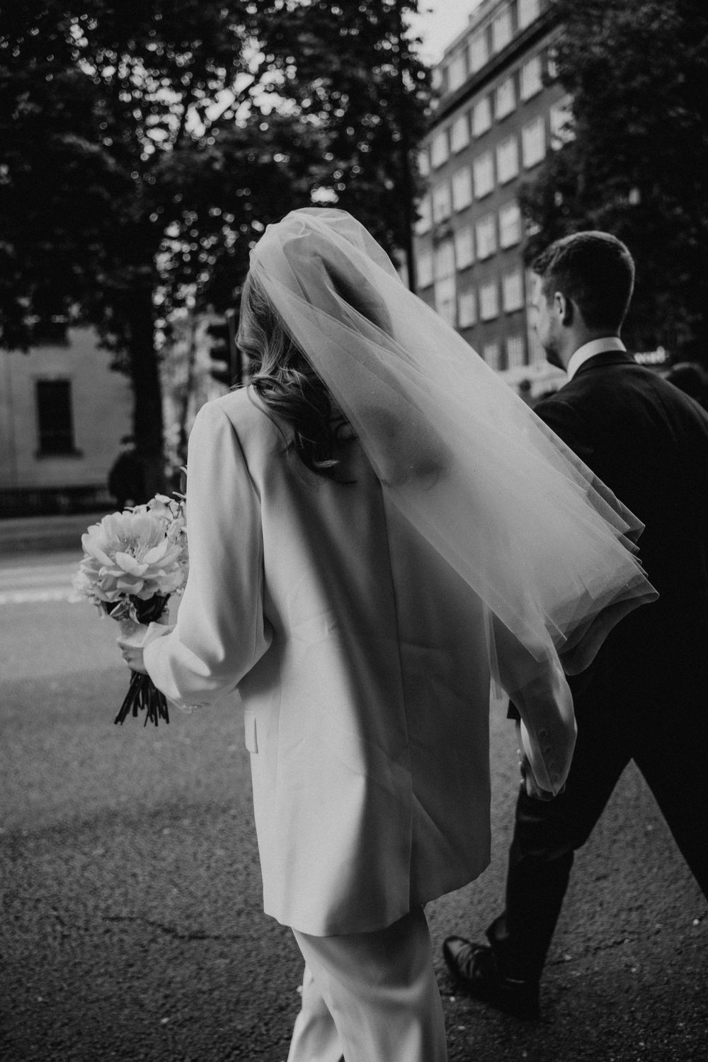 A black and white photo sequence shows a couple in wedding attire playfully dancing and twirling outdoors.