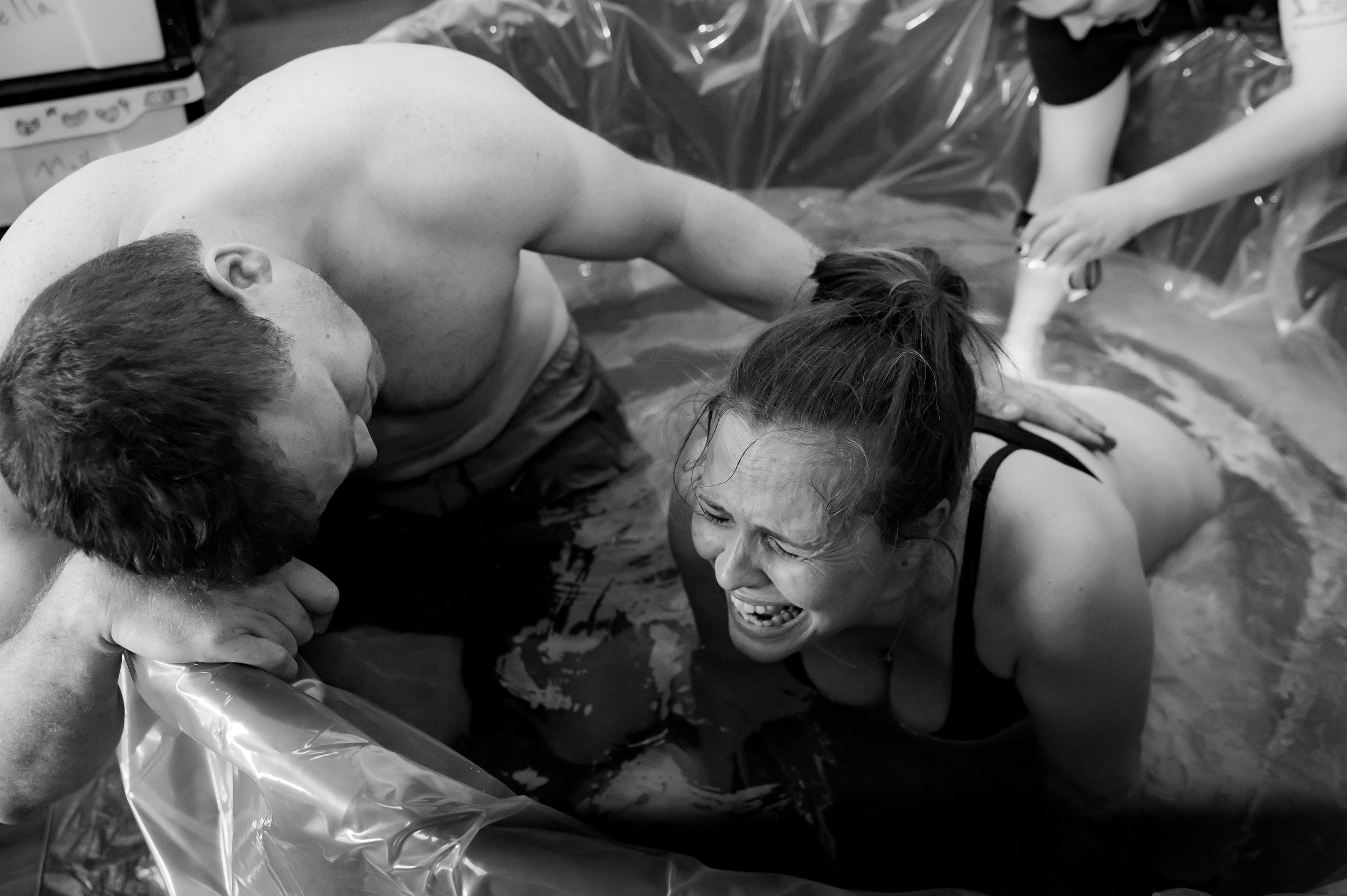 intense birthing moment of the final push before baby arrives at home birth