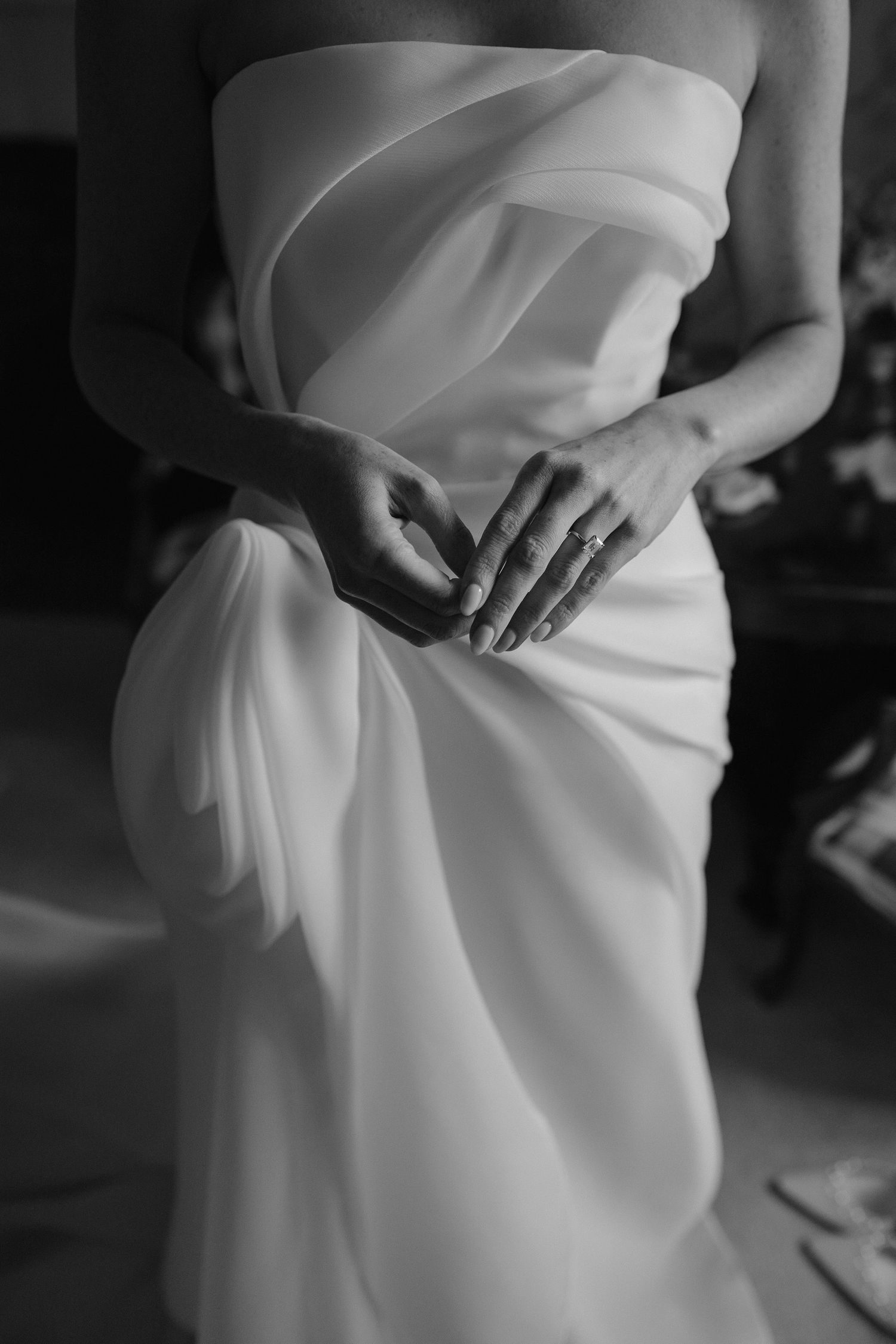 close up of brides hands and engagement ring against her wedding dress at dewsall court in herefordshire
