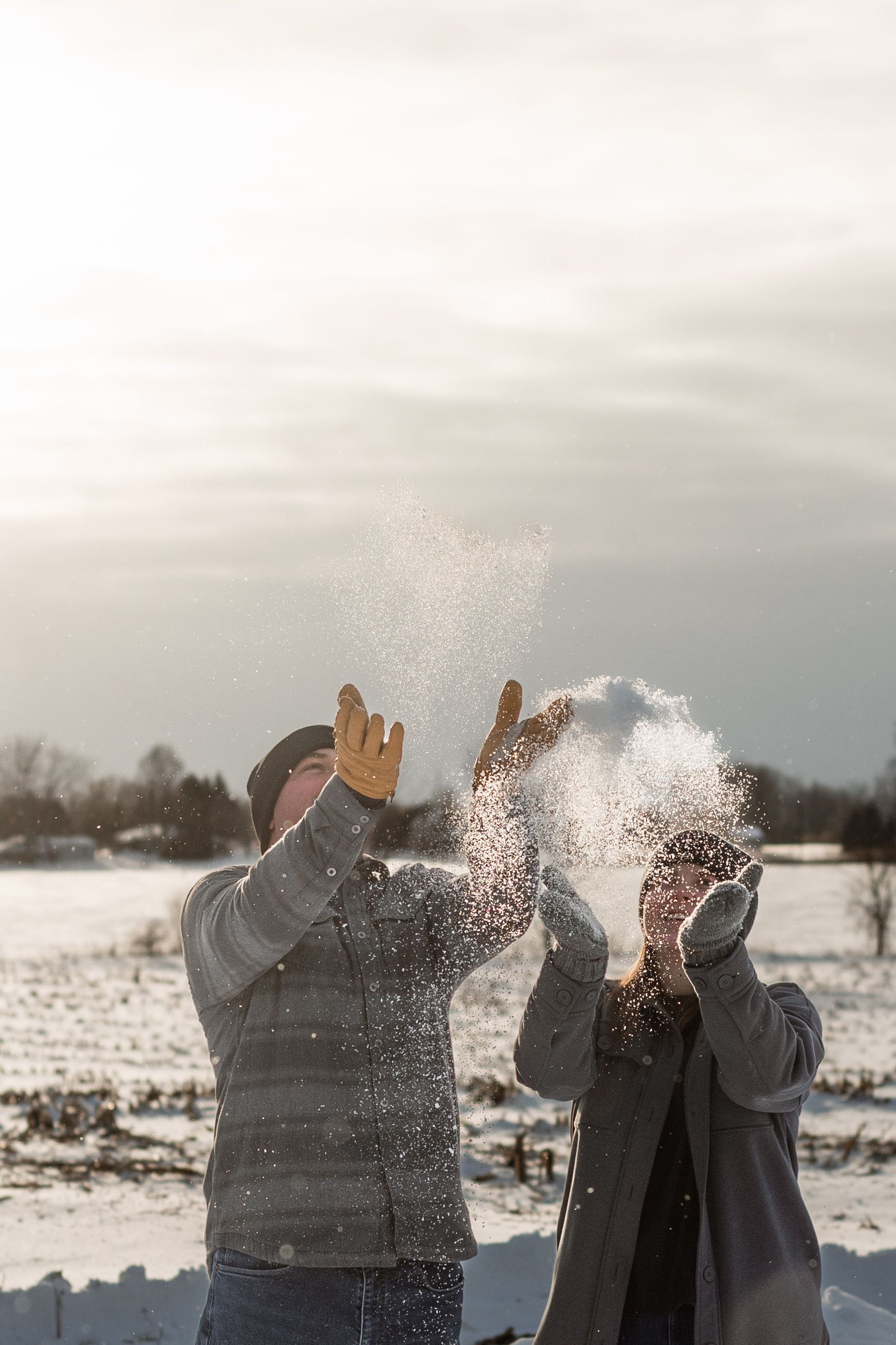 People having fun throwing snow at each other in a winter landscape during a playful outdoor moment.
