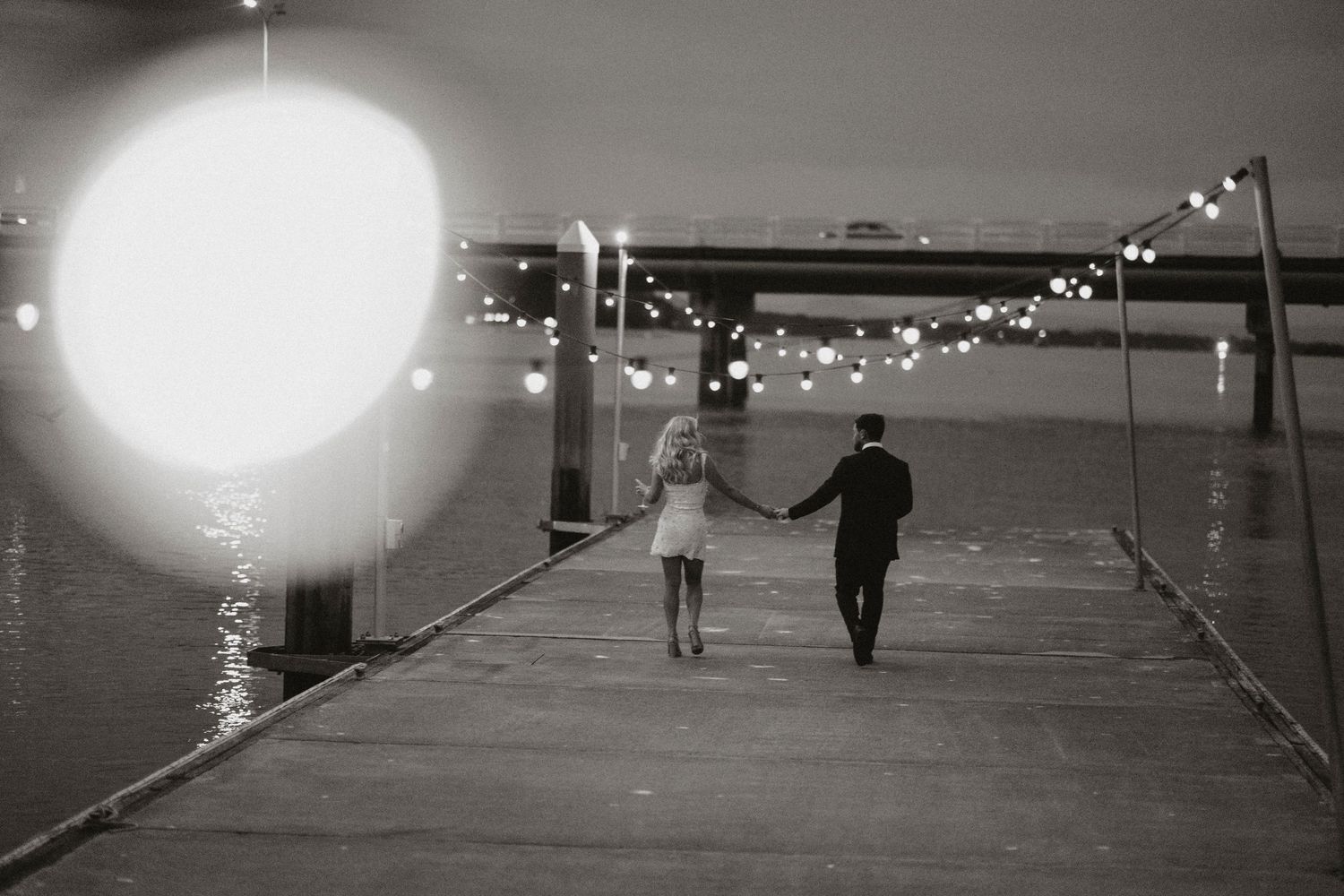 A black and white photo series showing a couple enjoying drinks and dancing at a wedding reception.