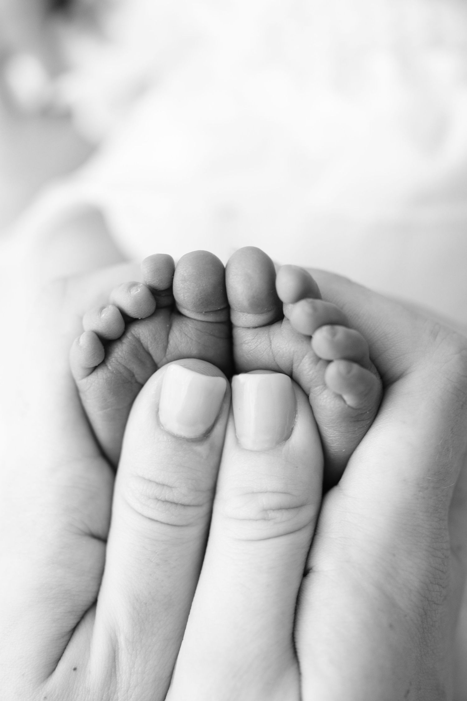 Close up black and white portrait of a sleeping newborn baby in soft focus with delicate lace details.