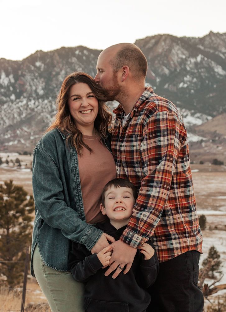 Parents and child share a tender moment together in a golden field during sunset | How I Help You Prep for Family Photos