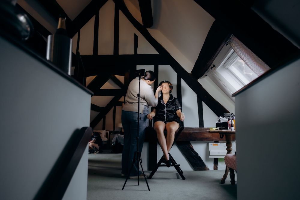 A person sits in a modern loft space with dark wooden beams and natural light streaming through windows.