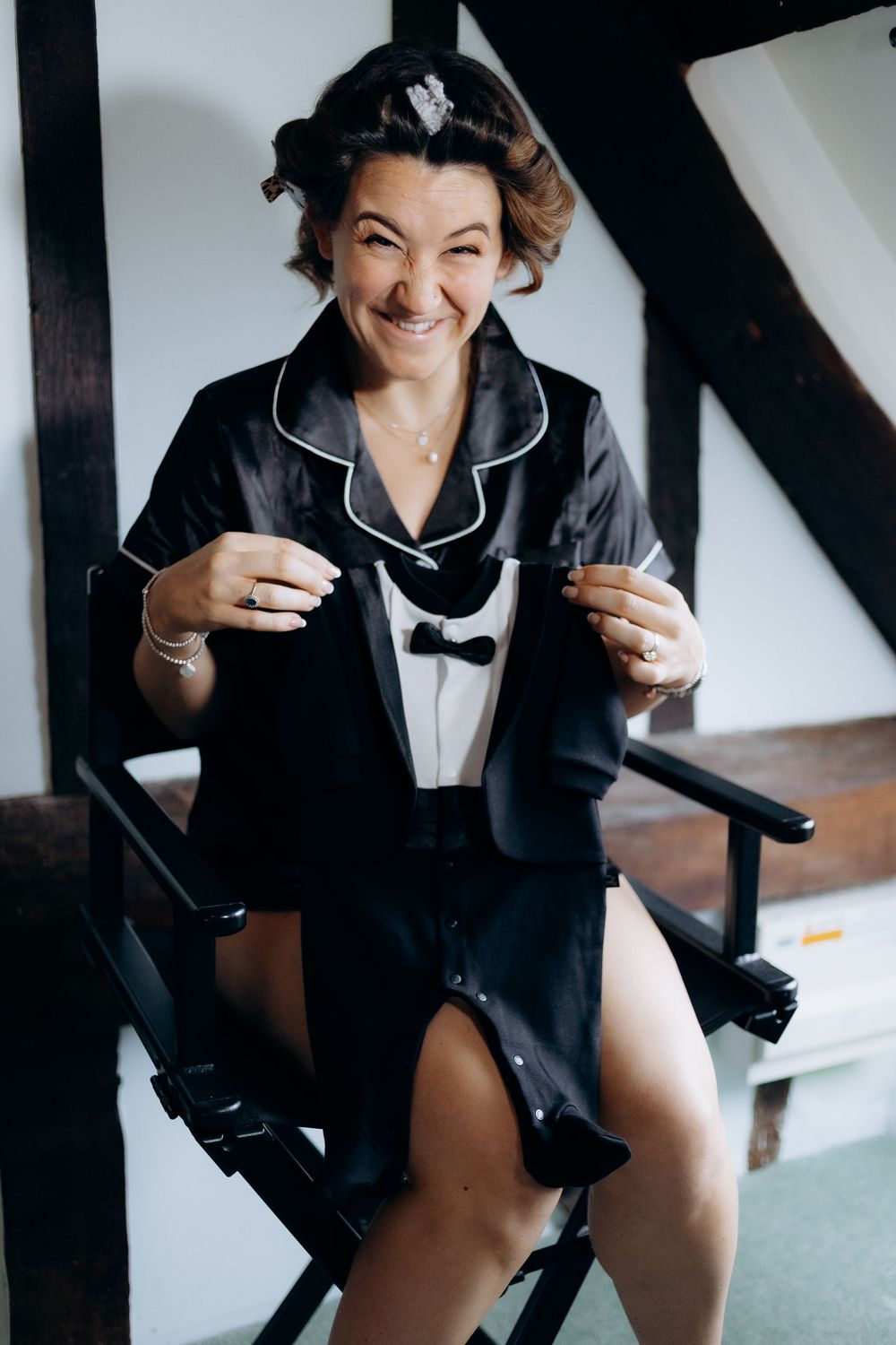 A series of boudoir photos showing a person in black silk pajamas posing playfully on a chair.