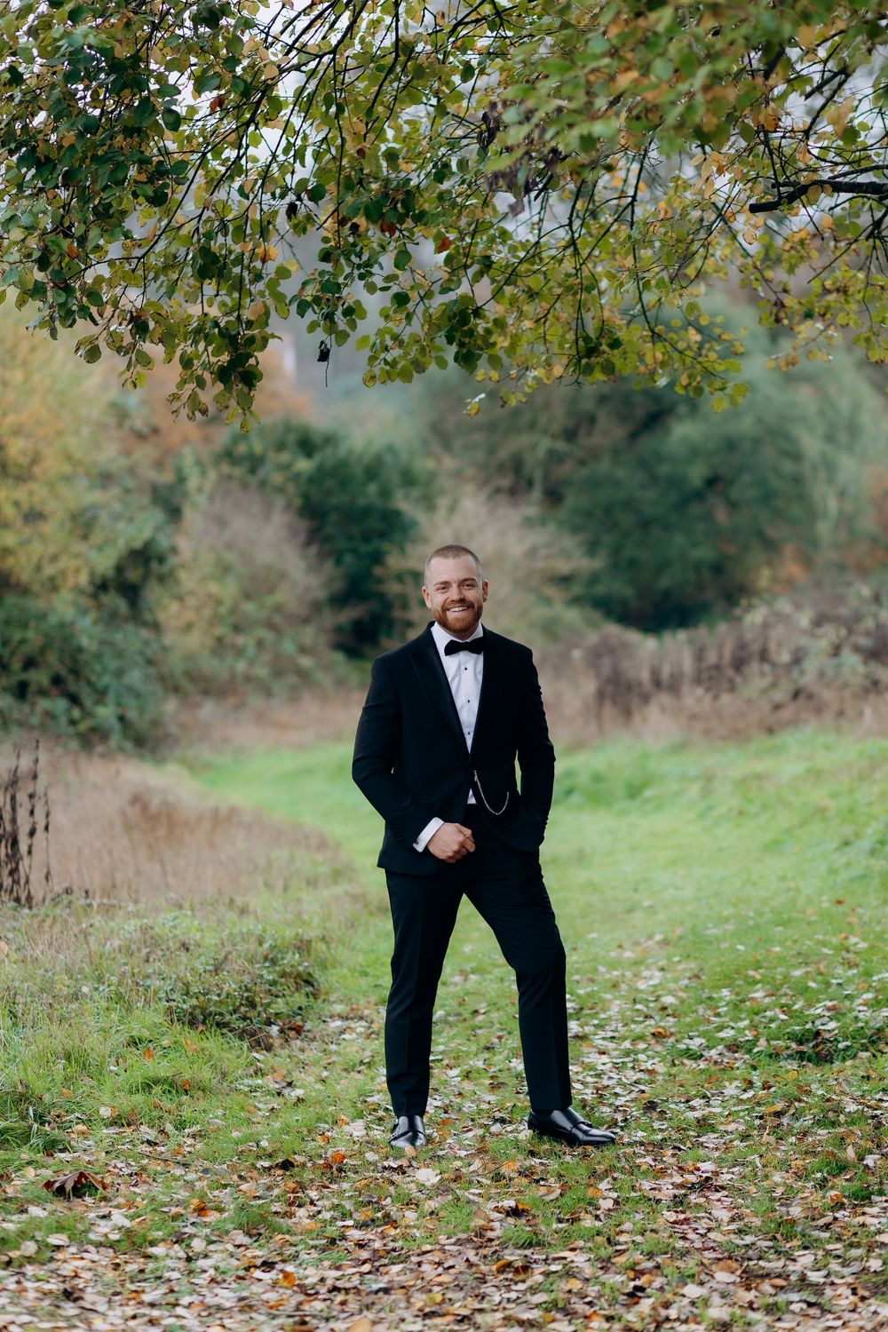 A sequence of playful poses outdoors in autumn with fallen leaves and green foliage in the background.