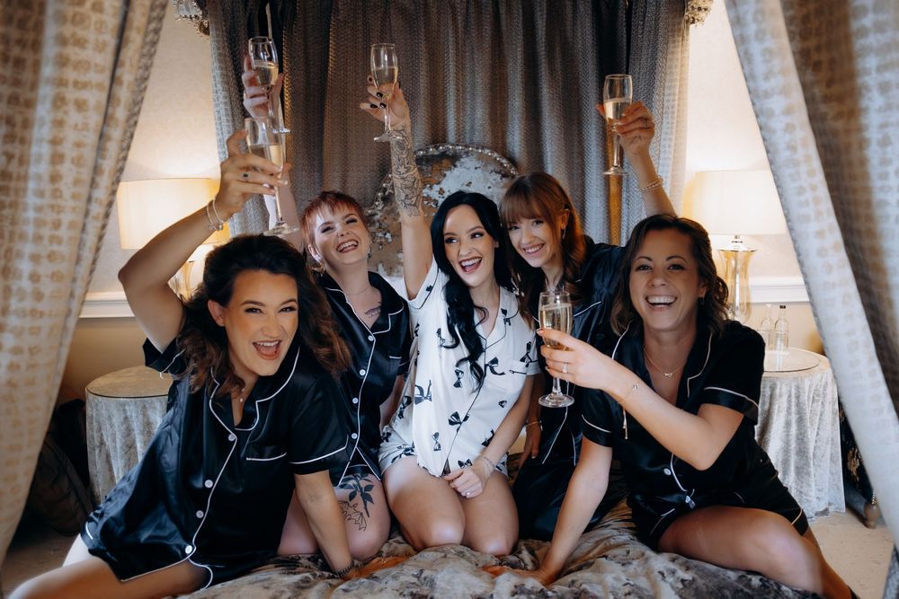 A group of people in formal attire pose together on a couch during a celebratory event.