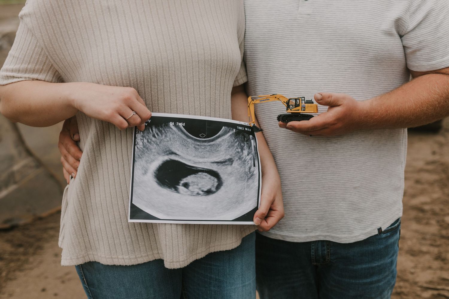 Couple holds an ultrasound photo showing their future baby in black and white.