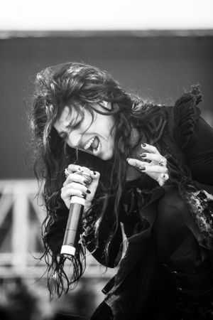 High contrast black and white photo capturing an emotional performance moment with microphone.