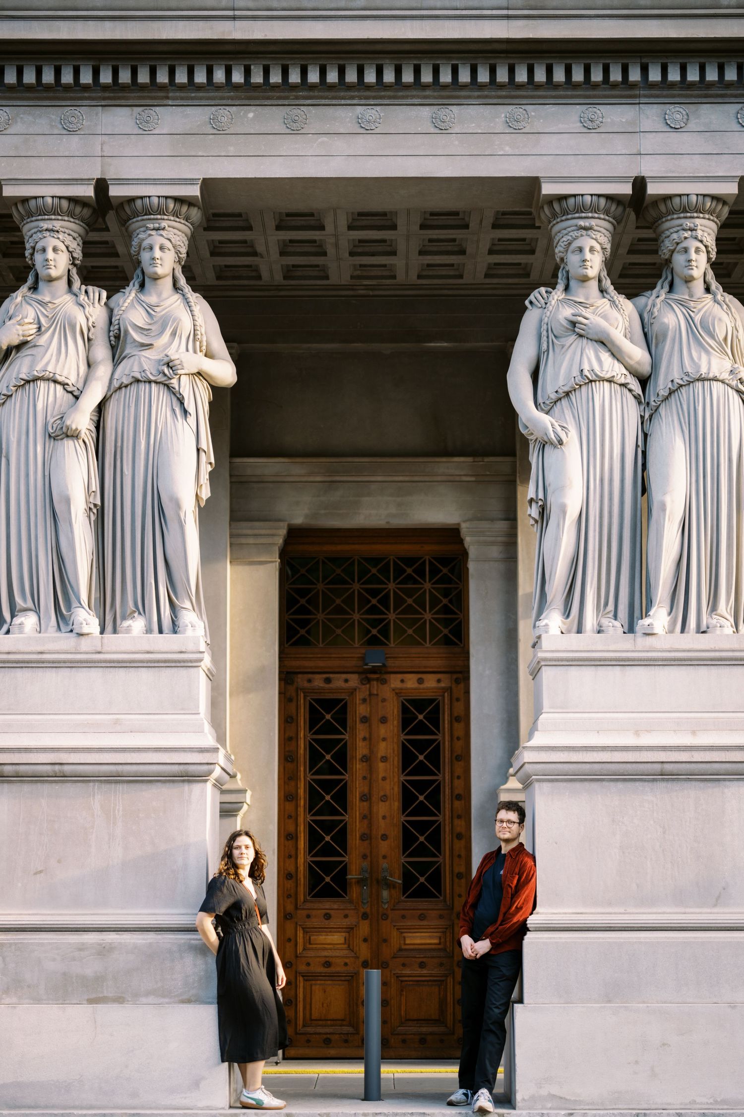 Ornate doorway entrance framed by tall neoclassical caryatid statues at a grand historical building.