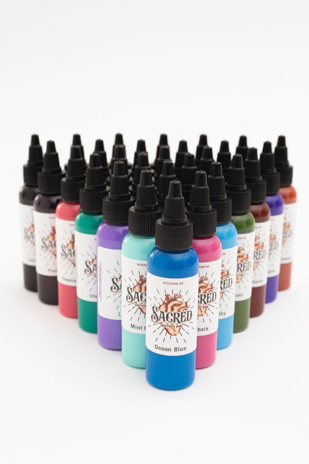 Collection of colorful tattoo ink bottles arranged in rows showcasing various vibrant shades.