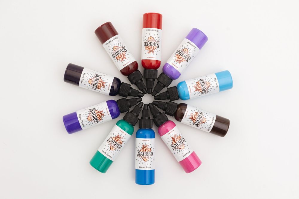 Tattoo ink bottles arranged in a circular pattern displaying an array of bright colors.