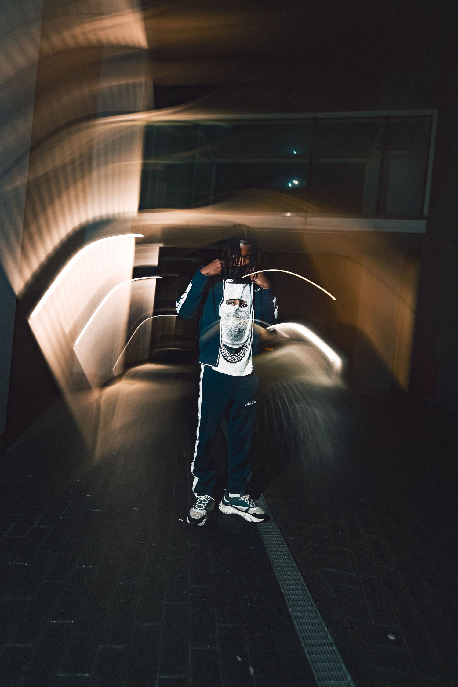 A person performs a skateboarding trick in a dimly lit tunnel with dramatic lighting creating motion blur effects.