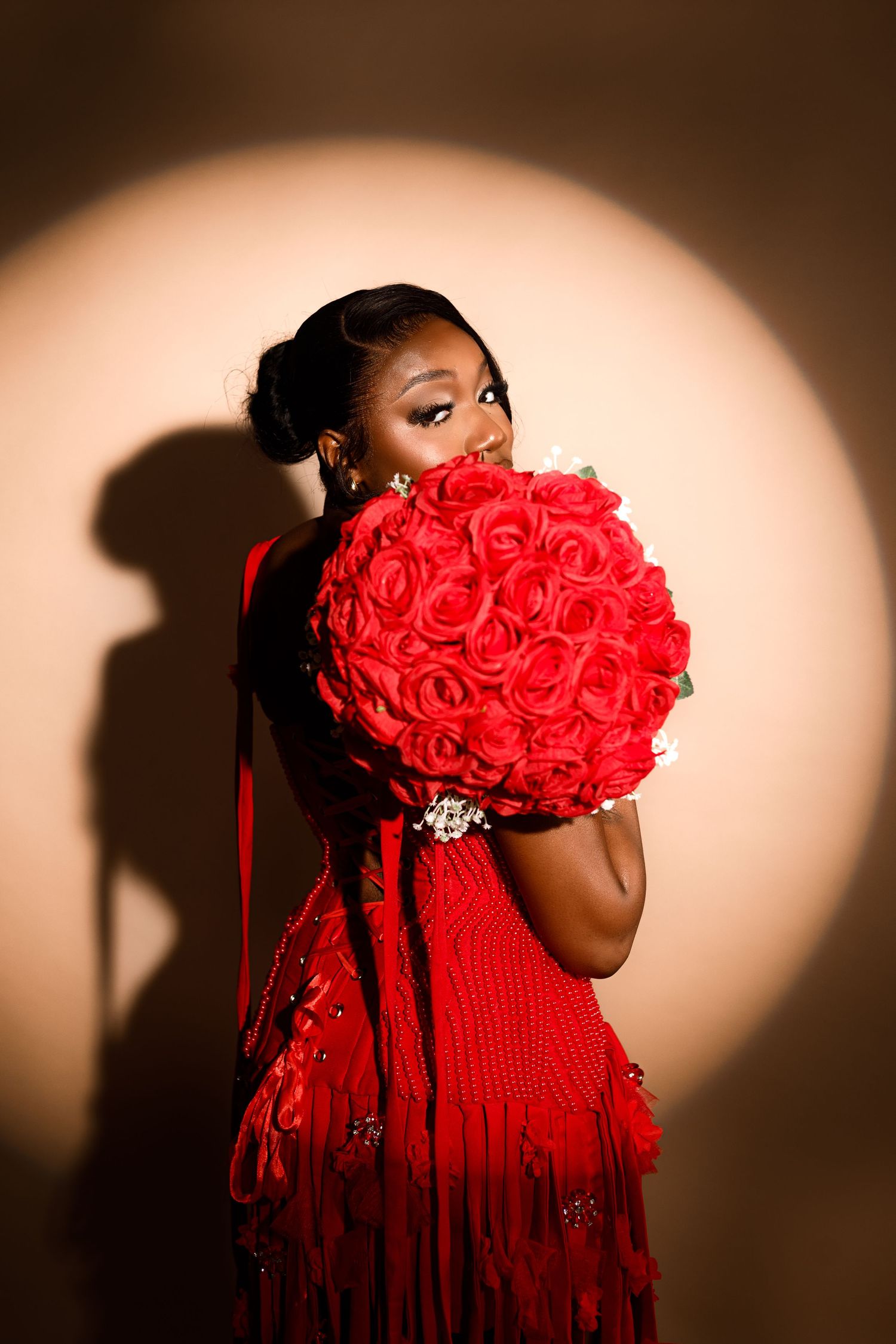 A series of artistic portraits featuring a red rose bouquet against a dark background with dramatic lighting.