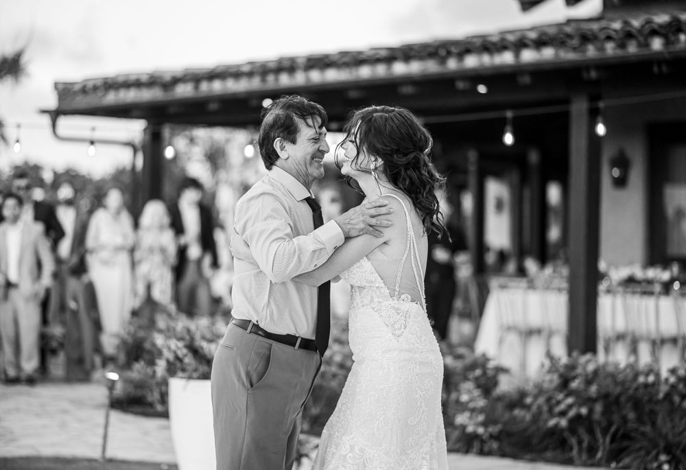 Black and white image of bride and groom sharing intimate moment during wedding dance.