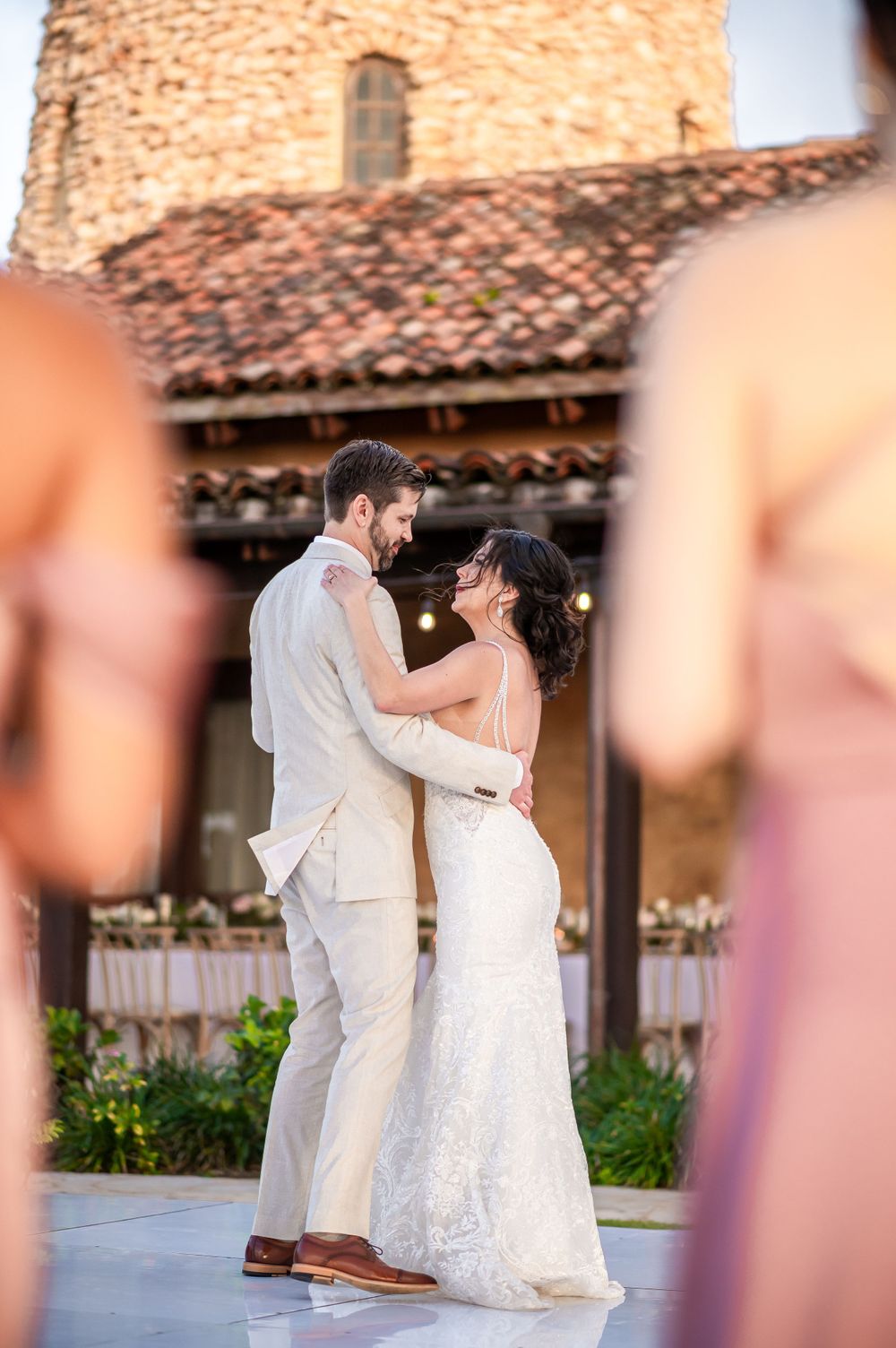 A romantic dance moment framed by the venue's distinctive stone tower and terracotta roof.