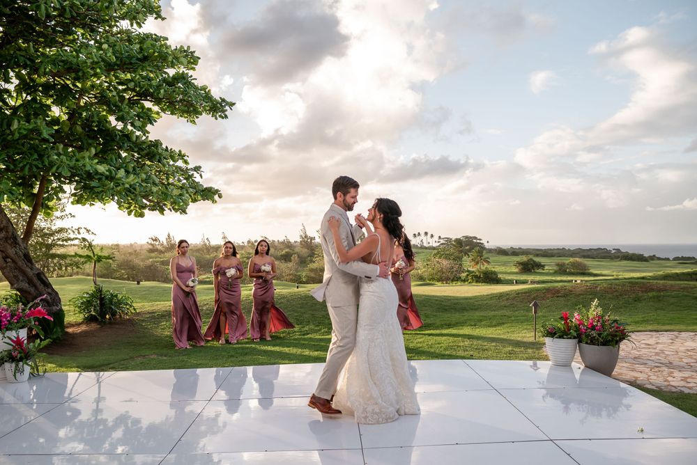 First dance on an outdoor dance floor with scenic views and sunset clouds in the background.