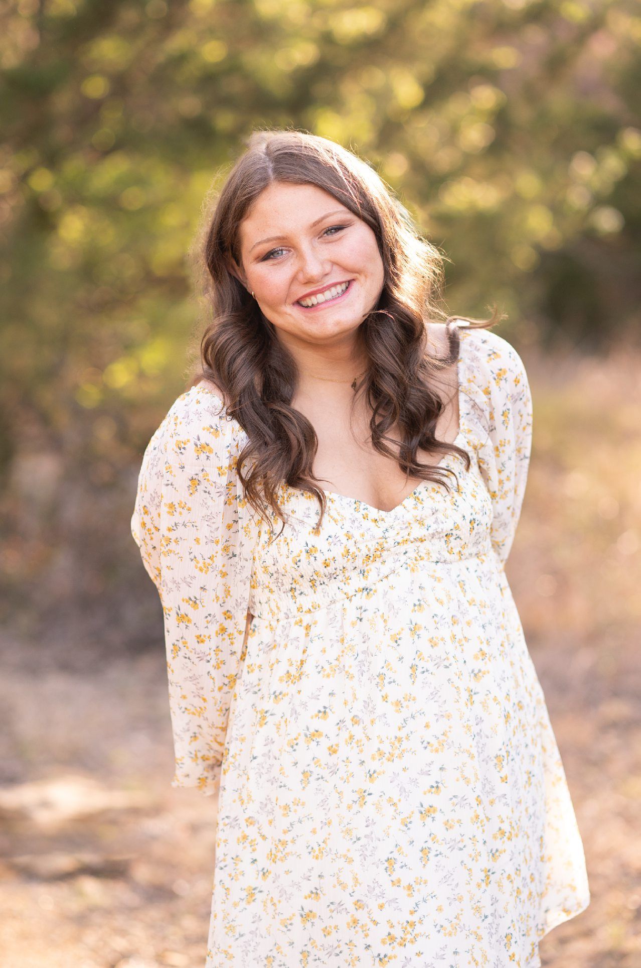 Senior Girl in Spring Field and Cap and Gown by Bartlesville Photographer Kristi Bray