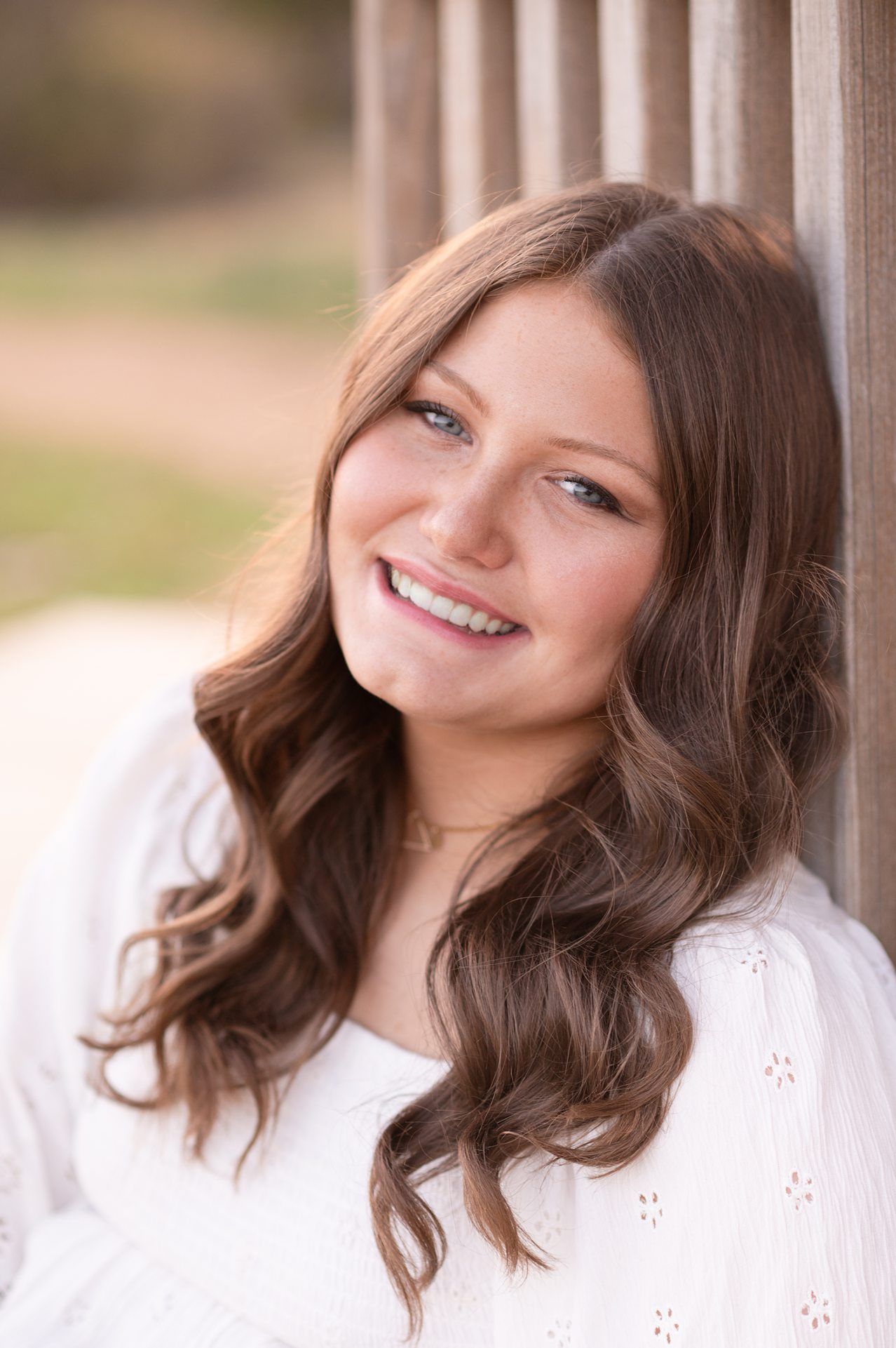 Senior Girl in Spring Field and Cap and Gown by Bartlesville Photographer Kristi Bray