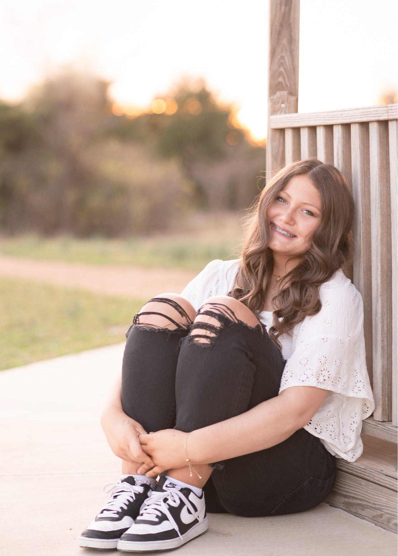 Senior Girl in Spring Field and Cap and Gown by Bartlesville Photographer Kristi Bray