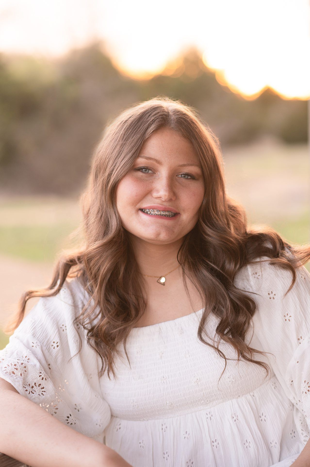 Senior Girl in Spring Field and Cap and Gown by Bartlesville Photographer Kristi Bray