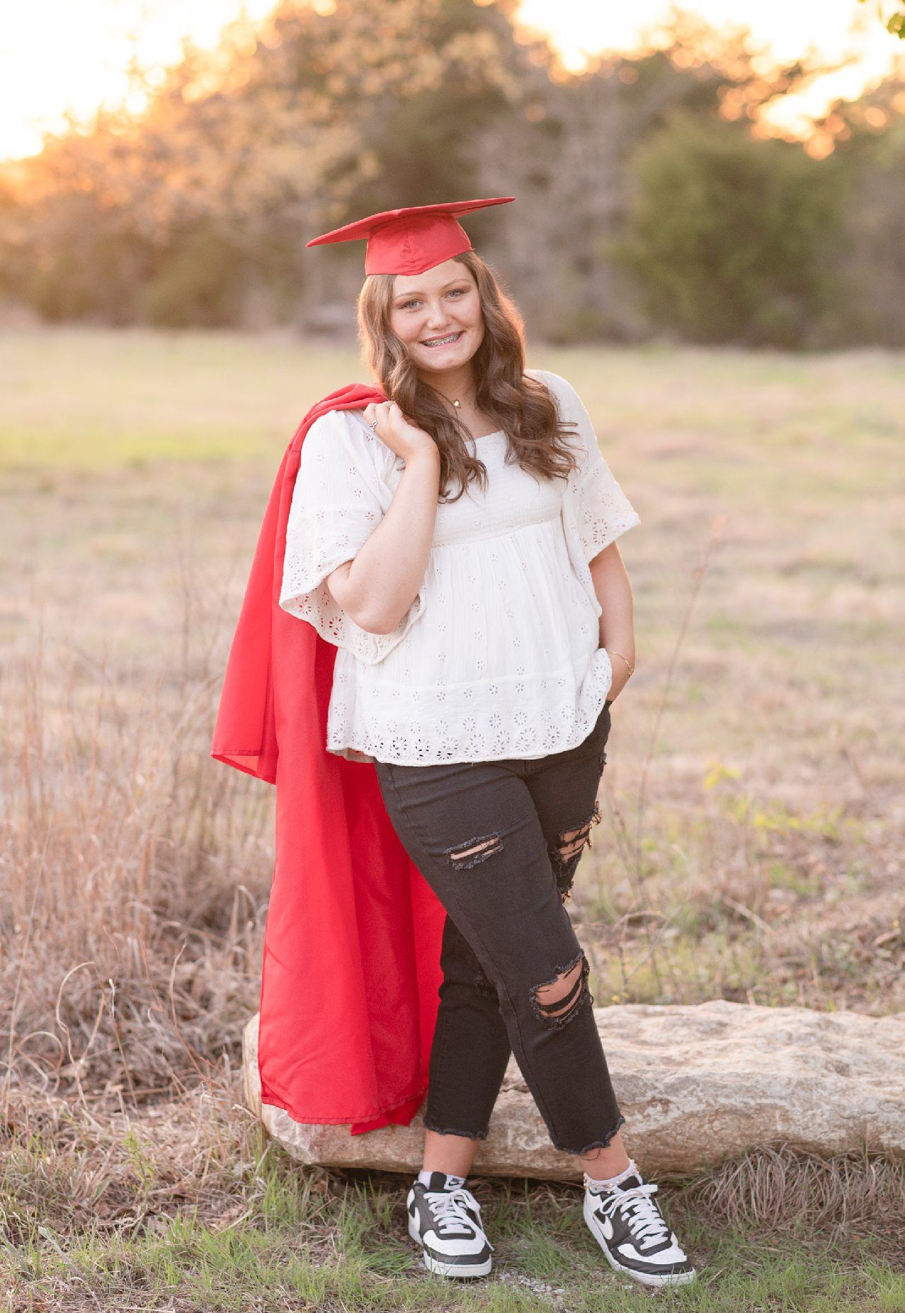 Senior Girl in Spring Field and Cap and Gown by Bartlesville Photographer Kristi Bray