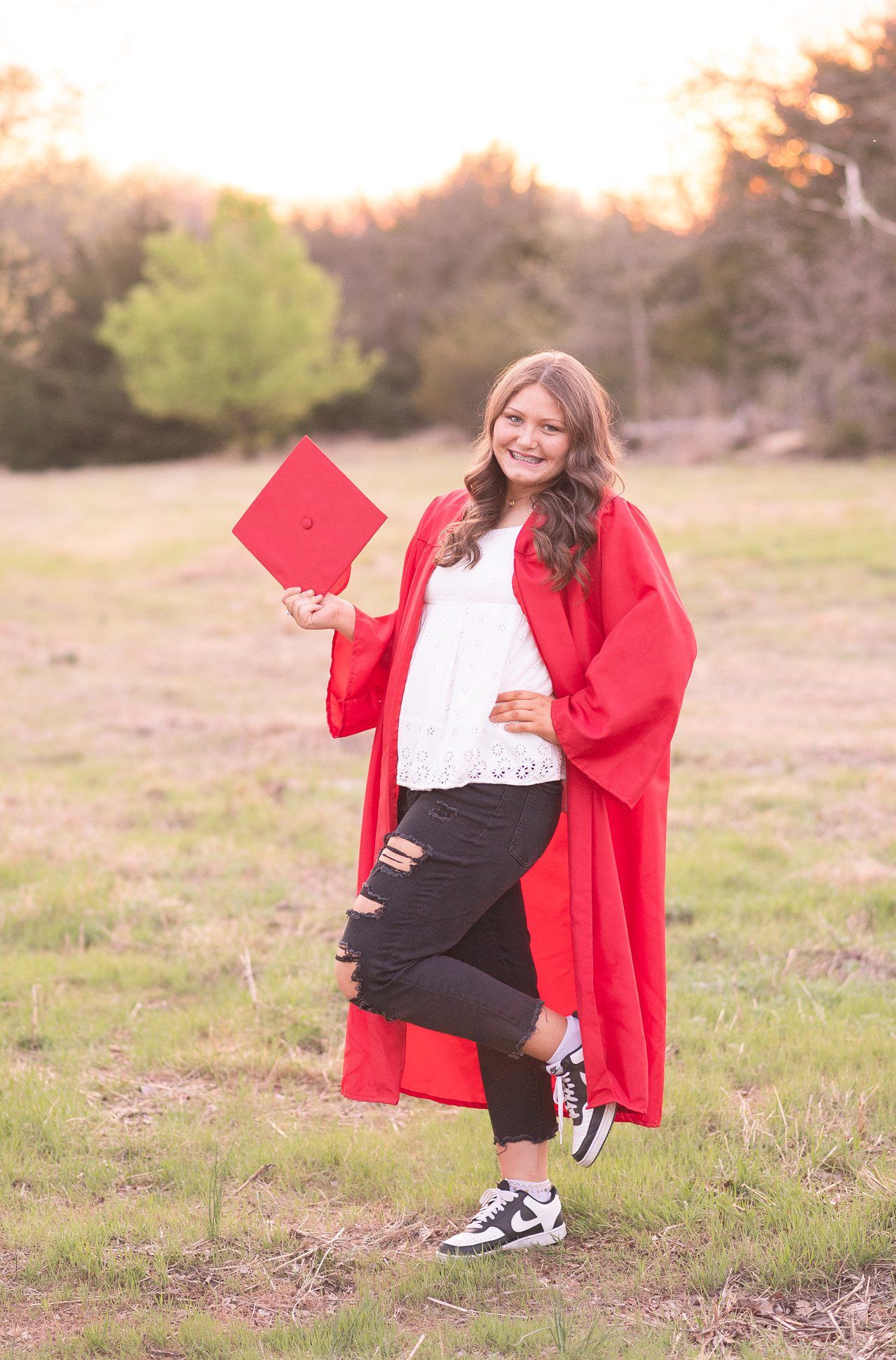 Senior Girl in Spring Field and Cap and Gown by Bartlesville Photographer Kristi Bray