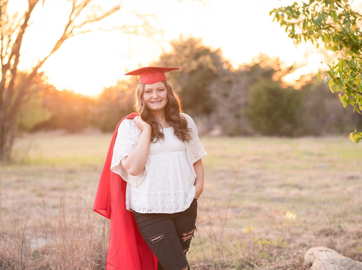 Senior Girl in Spring Field and Cap and Gown by Bartlesville Photographer Kristi Bray