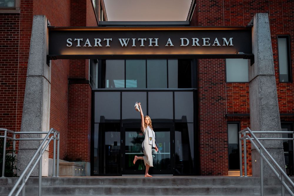 Building exterior with 'Start with a Dream' text signage.