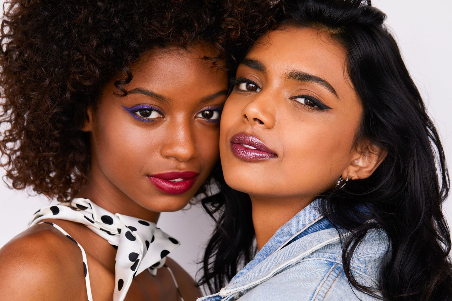 Fashion beauty portrait of two models with bold makeup and contrasting hairstyles.