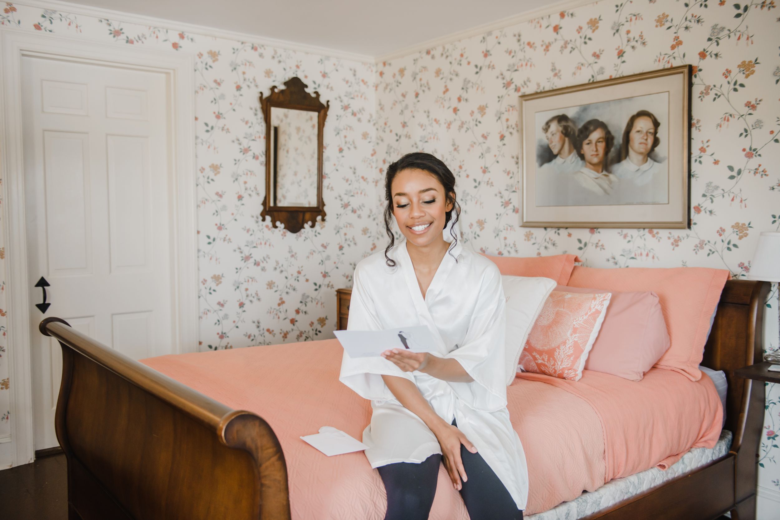 A relaxed morning scene in a bedroom with floral wallpaper and pink bedding.