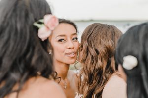 Intimate moment captured during beach wedding celebration with soft pink floral details.