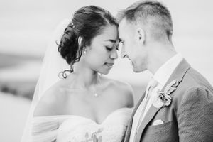 An intimate black and white portrait of a couple sharing a romantic moment on their wedding day.
