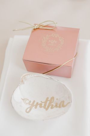 Pink gift box with gold details and personalized seashell name tag.