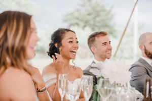 Wedding guests laughing together during reception dinner.